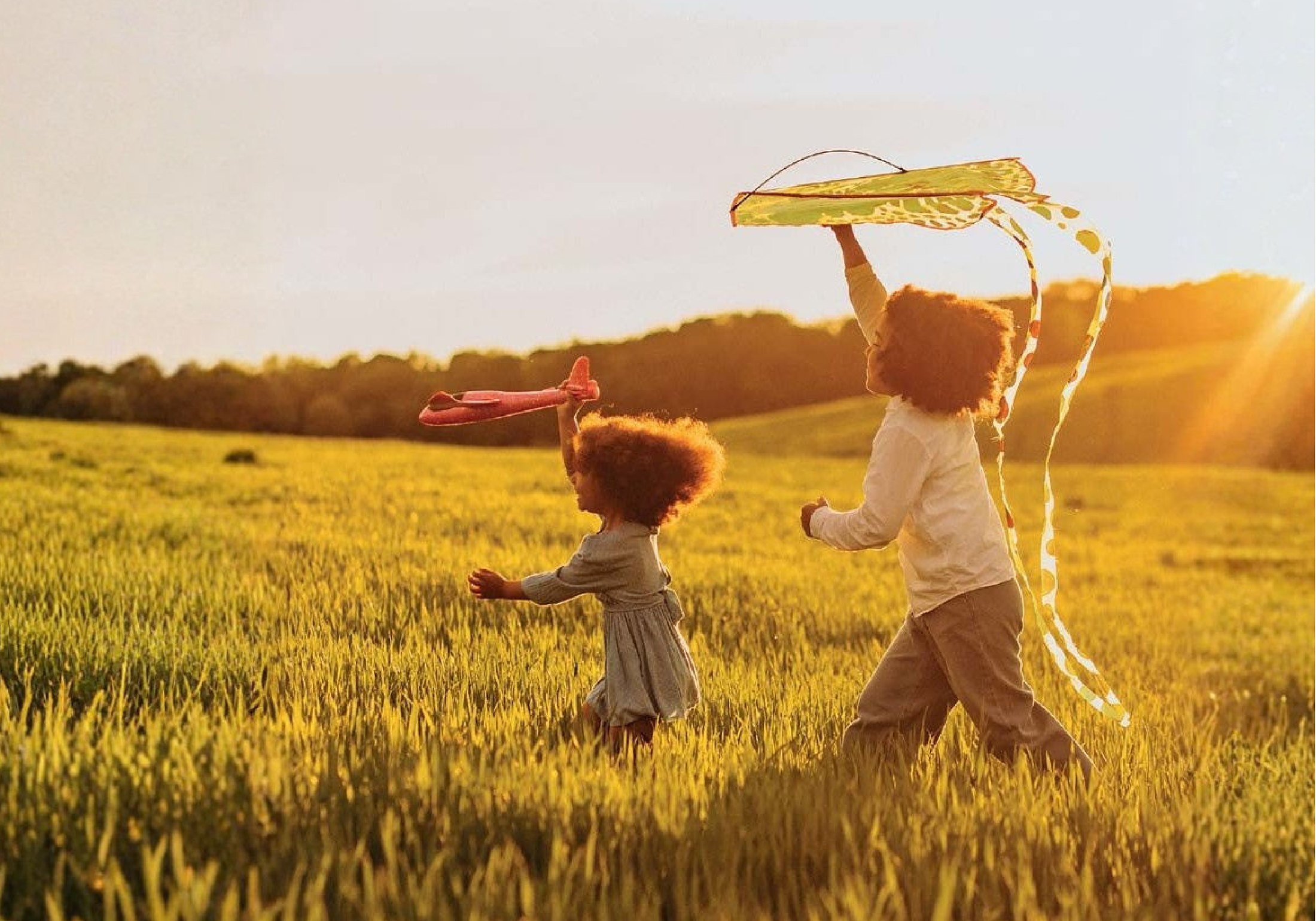 Children flying kites at sunset on the estate lawns
